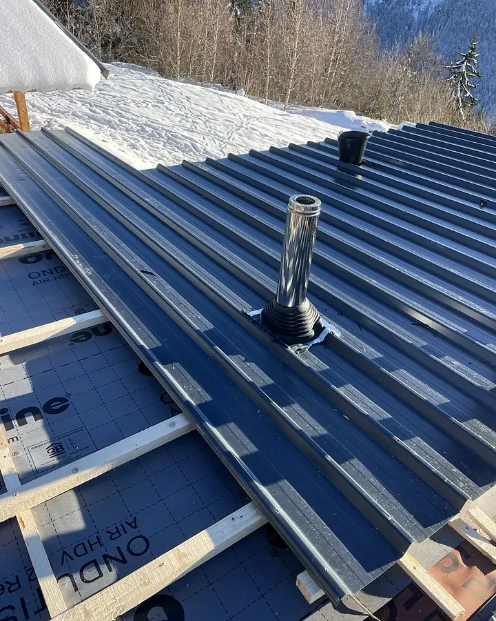 Sortie de conduit inox et collerette d'étanchéité. Chalet en montagne, bac acier, chantier de Trois Massifs Toiture.
